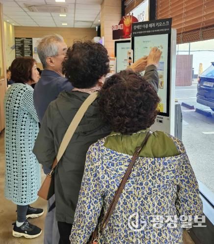 밀양시 삼문동 맥도날드 밀양DT점에서 열린 디지털 키오스크 문해교육 현장실습에 참여한 학습자들이 키오스크를 직접 조작하며 주문을 연습하고 있다.