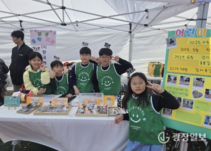 아동창업팀 수공예품 판매 부스에서 아이들이 포즈를 취하고 있다.