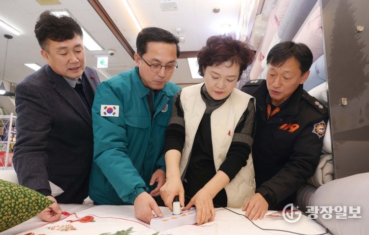 박희조 동구청장이 인동시장 상점가 전기 콘센트에 자동소화패치를 설치하는 모습