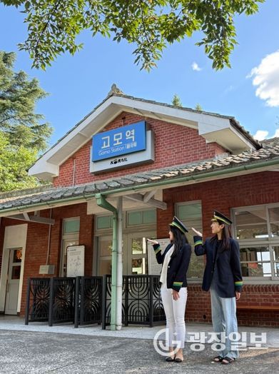 관광객들이 고모역에서 역무원 체험을 하고 있다.