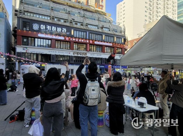 시민들이 인플루언서 크림서현과 랜덤댄스 챌린지 참여자들의 공연을 관람하고 있다.