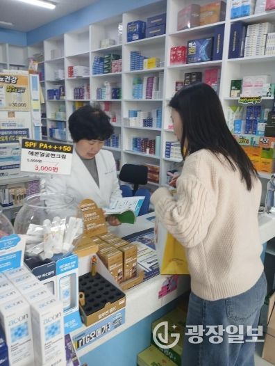 남구 치매안심약국 약사가 치매안심센터 직원의 설명을 듣고 있는 모습